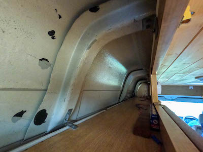 Top cupboard with exposed skin of the van